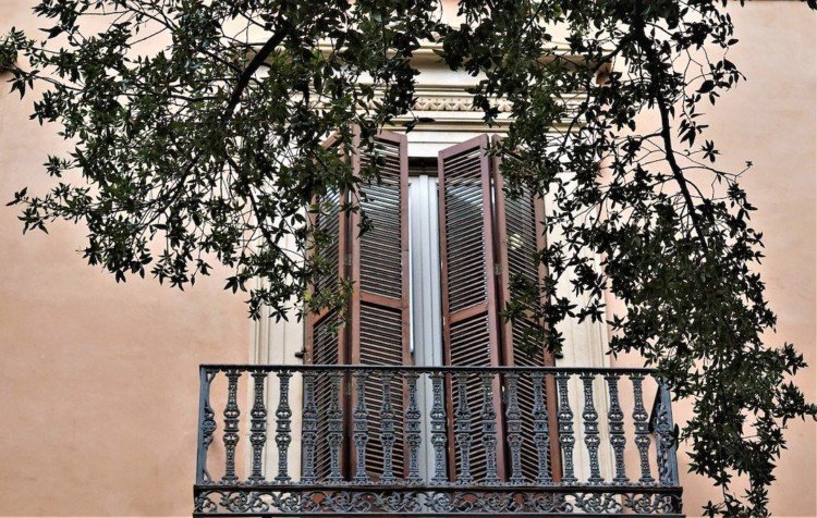 Balcon de maison avec des volets mi-clos